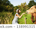 Woman, horse and feeding grass in field with smile, care and love for pet at farm, countryside and spring. Girl, equine animal and happy with food for health, nutrition and diet in meadow for summer 138991315