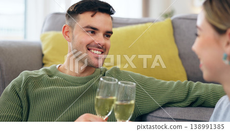 Couple, happy man and champagne for cheers in living room for celebration, anniversary and event. Husband, face and smile with spouse for good news with drink, glass and home for sitting on floor Couple, happy man and champagne for cheers in living room for celebration, anniversary and event. Husband, face and smile with spouse for good news with drink, glass and home for sitting on floor 138991385
