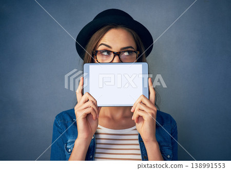 Face, tablet and space with a fashion woman in studio on a blue background for social media marketing. Idea, display and style with a young person holding an empty screen for advertising mockup Face, tablet and space with a fashion woman in studio on a blue background for social media marketing. Idea, display and style with a young person holding an empty screen for advertising mockup 138991553
