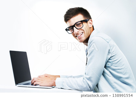 Portrait, business man typing on laptop at table and isolated on white background. Face, smile and geek at desk on computer, technology and IT programmer in glasses, coding and mockup space in Canada Portrait, business man typing on laptop at table and isolated on white background. Face, smile and geek at desk on computer, technology and IT programmer in glasses, coding and mockup space in Canada 138991554