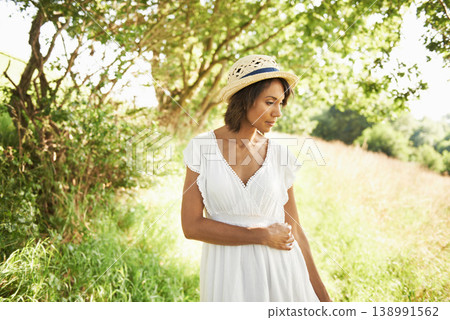 Woman, field and spring with hat, sunshine and thinking on walk in green nature for memory, relax and adventure. Girl, outdoor and ideas by trees, grass and freedom on countryside holiday in summer 138991562