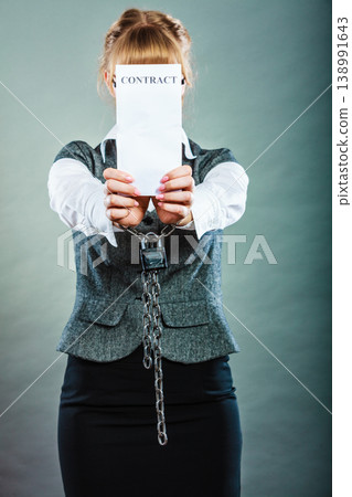 businesswoman with chained hands holding contract businesswoman with chained hands holding contract 138991643