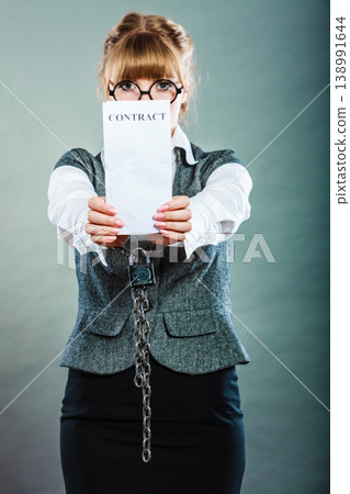 businesswoman with chained hands holding contract 138991644