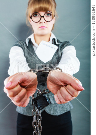 businesswoman with chained hands holding contract businesswoman with chained hands holding contract 138991645