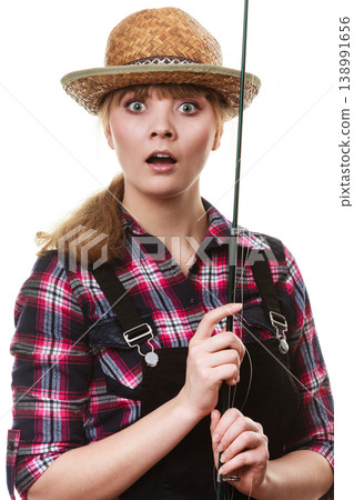 Shocked woman in sun hat holding fishing rod Shocked woman in sun hat holding fishing rod 138991656