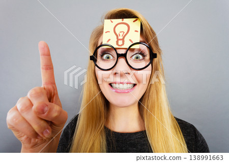 Woman having light bulb mark on forehead thinking Woman having light bulb mark on forehead thinking 138991663