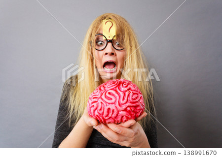 Weird woman holding brain having idea Weird woman holding brain having idea 138991670