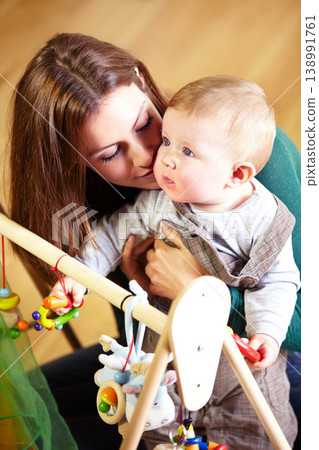 Woman, baby and holding for playing with toys in living room for childhood development in home. Mother, son and bonding for love, trust or together by support in growth, future and hope with care Woman, baby and holding for playing with toys in living room for childhood development in home. Mother, son and bonding for love, trust or together by support in growth, future and hope with care 138991761