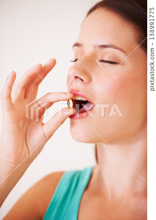 Healthy, woman and eating a supplement, pill and tablet for nutrition, diet and vitamin c benefits. Happy, face and girl with pharmaceutical capsule with omega 3, magnesium and healthcare medicine 138991775