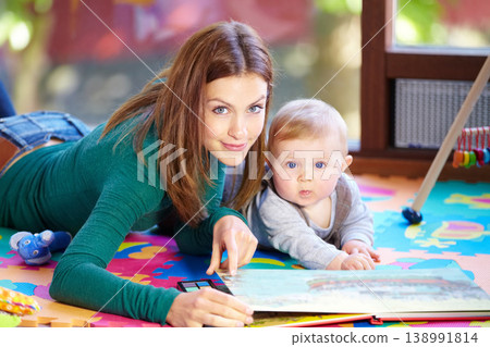 Portrait, woman and baby with book in home for learning, development or cognitive growth for education. Mother, son or family with reading, bond and lying on floor in living room with toys for future Portrait, woman and baby with book in home for learning, development or cognitive growth for education. Mother, son or family with reading, bond and lying on floor in living room with toys for future 138991814