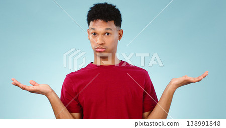 Portrait, man and shrug for doubt in studio for promotion with mock up for option, decision or choice. Male model, face and unsure or confused with presentation, scale or deal on blue background 138991848