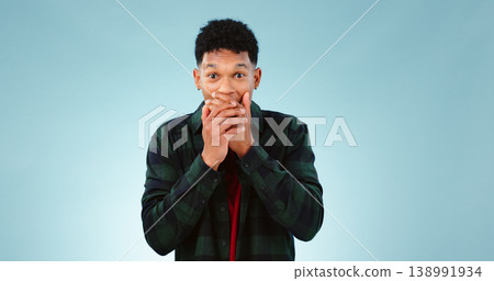 Surprise, shock and hands on face of man in studio with wow, news or announcement on blue background. Omg, portrait and male model with emoji gesture for unexpected results, feedback or secret gossip 138991934