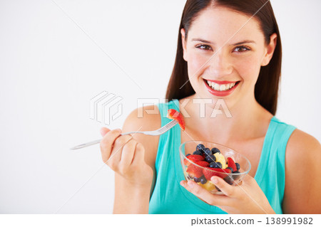 Food, fruit salad and portrait of woman with smile eating for nutrition, wellness and berry snack in studio. Health, happy and face of person for vitamins, diet and lose weight on white background 138991982