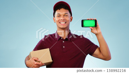 Courier man, phone and green screen in studio for smile, mockup space or box by blue background. Supply chain expert, cardboard package and smartphone for app promotion, chromakey or tracking markers 138992216