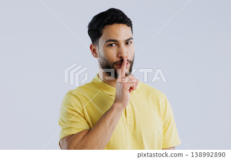 Secret, man and portrait in studio for sign of privacy, surprise sales and confidential deal on white background. Indian model with finger on lips for quiet, gossip news and mystery emoji to whisper Secret, man and portrait in studio for sign of privacy, surprise sales and confidential deal on white background. Indian model with finger on lips for quiet, gossip news and mystery emoji to whisper 138992890
