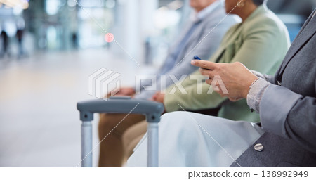 Airport, luggage and hands of person with phone for social media, internet and online booking. Travel, business and closeup on typing on smartphone in line for check in, flight schedule or mobile app Airport, luggage and hands of person with phone for social media, internet and online booking. Travel, business and closeup on typing on smartphone in line for check in, flight schedule or mobile app 138992949