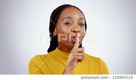Secret, woman and portrait with finger on lips in studio for sign of privacy, confidential deal and surprise on white background. Face of african model show quiet emoji for gossip, news and whisper Secret, woman and portrait with finger on lips in studio for sign of privacy, confidential deal and surprise on white background. Face of african model show quiet emoji for gossip, news and whisper 138993129