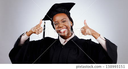Graduation, thumbs up and woman or student success with celebration, education and learning or college achievement in studio. Portrait of happy african graduate with like emoji on a white background 138993151