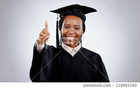 Graduation cap, thumbs up and woman or student success with celebration, education and learning or college achievement in studio. Portrait of an african graduate with like emoji on a white background 138993160