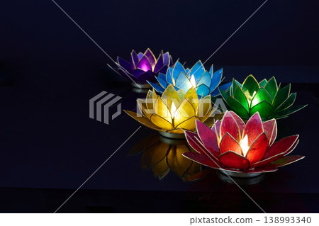 Vesak. Colorful lotus flower tea light candles glowing in dark water Vesak. Colorful lotus flower tea light candles glowing in dark water 138993340