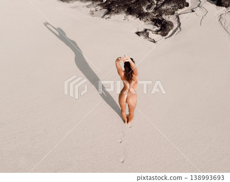 Naked woman sunbathing on sandy beach near the ocean. Naked woman sunbathing on sandy beach near the ocean. 138993693