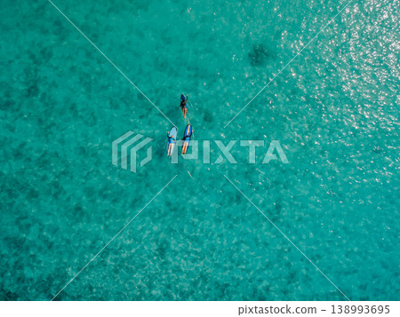 Aerial view of surfers on turquoise ocean in Bali, tropical summer vacation background Aerial view of surfers on turquoise ocean in Bali, tropical summer vacation background 138993695