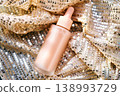 Cosmetic serum bottle on shimmering sequin fabric 138993729