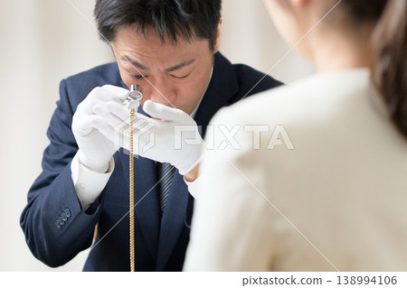 戴著白手套的鑑定師在回購鑑定過程中檢查一件配件的狀況。 138994106