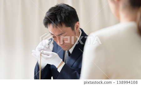 戴著白手套的鑑定師在回購鑑定過程中檢查一件配件的狀況。 138994108