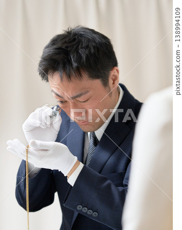 戴著白手套的鑑定師在回購鑑定過程中檢查一件配件的狀況。 138994109