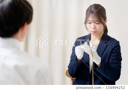 一位戴著手套的女鑑定師正在用放大鏡檢查一件物品。 一位戴著手套的女鑑定師正在用放大鏡檢查一件物品。 138994252