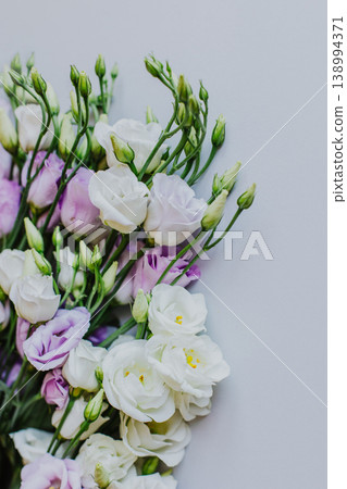Beautiful white and purple Eustoma (Lisianthus) flowers on a pastel background. Beautiful white and purple Eustoma (Lisianthus) flowers on a pastel background. 138994371