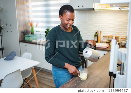 Woman pouring hot water into mug with lemon 138994487