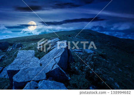 rocks and rolling hills in mountain landscape in summer at night. full moon over scenery with green grass on alpine meadow under dark sky with clouds. mysterious recreation tourism and wanderlust rocks and rolling hills in mountain landscape in summer at night. full moon over scenery with green grass on alpine meadow under dark sky with clouds. mysterious recreation tourism and wanderlust 138994682