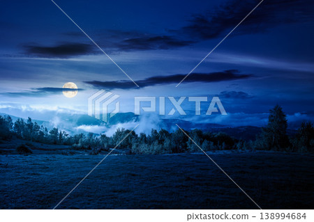 carpathian mountain landscape on a foggy night. outdoor adventure with stunning view. full moon over countryside landscape with rolling hills, fog and cloudy sky. mysterious fantasy carpathian mountain landscape on a foggy night. outdoor adventure with stunning view. full moon over countryside landscape with rolling hills, fog and cloudy sky. mysterious fantasy 138994684