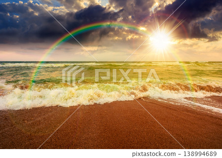 sunset over storm on the sandy beach. wonderful sea view with cloudy sky. salt water and crashing waves. view of bulgaria beach in summer. wind weather background under rainbow sunset over storm on the sandy beach. wonderful sea view with cloudy sky. salt water and crashing waves. view of bulgaria beach in summer. wind weather background under rainbow 138994689
