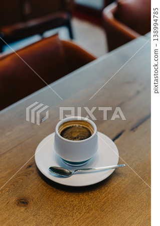 Cup of black coffee on a wooden table in a cafe. Cup of black coffee on a wooden table in a cafe. 138994785