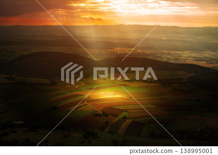 Sunlit Farmland Landscape in Austria, beautiful view with the sun ray Sunlit Farmland Landscape in Austria, beautiful view with the sun ray 138995001