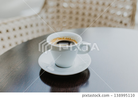 Cup of black coffee on a wooden table in a street cafe. Cup of black coffee on a wooden table in a street cafe. 138995110
