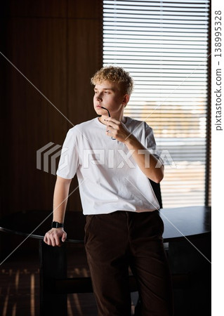 Contemplative young man captures relaxed mood in bright interior Contemplative young man captures relaxed mood in bright interior 138995328