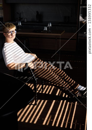 Teenager calmly seated surrounded by eyecatching patterns and rhythm 138995332