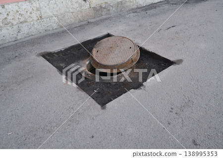 Street maintenance activity with exposed manhole and debris present Street maintenance activity with exposed manhole and debris present 138995353