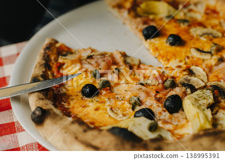 Delicious pizza Capricciosa in a traditional Italian pizzeria. 138995391