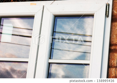 Close up of white plastic window frame with glass panes and reflections 138995416