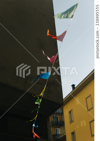 Colorful flags in the sky on the street of Milan. Italy. Colorful flags in the sky on the street of Milan. Italy. 138995555