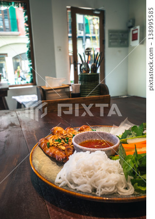 A platter of Vietnamese Nem Nuong: pork meatballs, rice noodles, herbs, and vegetables. 138995585