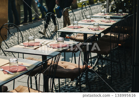 Tables served for lunch in a street cafe on a sunny day. Tables served for lunch in a street cafe on a sunny day. 138995616