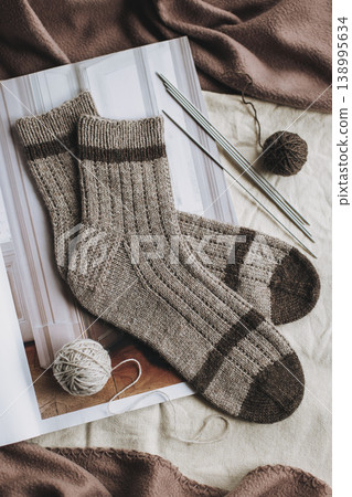 Hand knitted socks with needles and yarn ball. Concept for handmade and hygge slow life. Hand knitted socks with needles and yarn ball. Concept for handmade and hygge slow life. 138995634