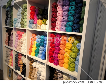 Multicolored skeins of knitting yarn on shelves in a craft store Multicolored skeins of knitting yarn on shelves in a craft store 138995786
