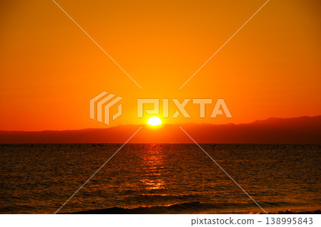 The sky and sea are dyed orange by the morning sun. 138995843